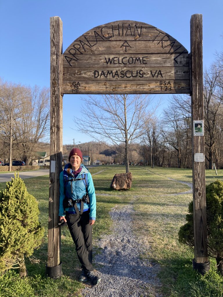Carolyn standing next to the sign in Damascus, Virginia on the Appalachian Trail