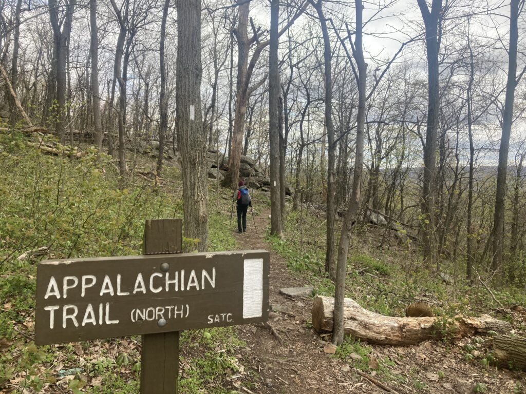 Carolyn hiking along the Appalaching trail with a trail sign