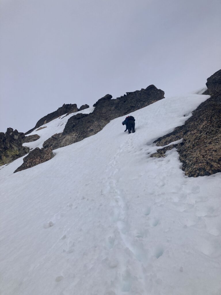 Carolyn climbs down steep snow on Emerald Peak in the Entiat Wilderness