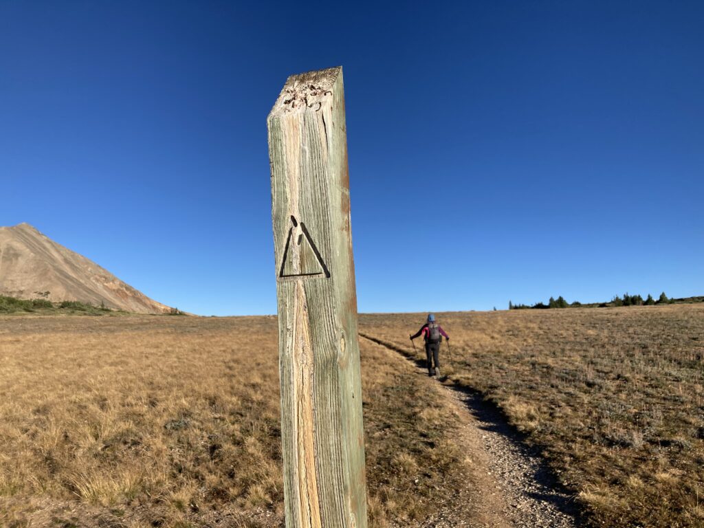 Carolyn hikes past a trail marker on the Northern Section of the Colorado Trail