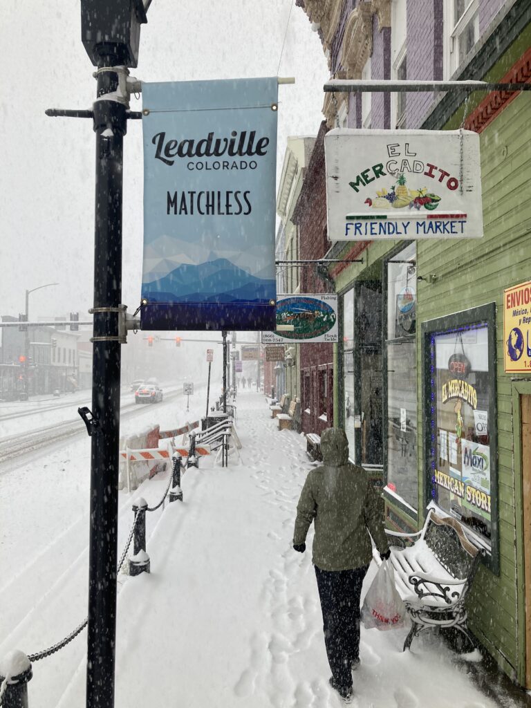 Carolyn walking down the street in Leadville in a snowstorm