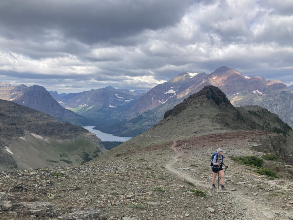 Carolyn hiking up a beautiful ridge line in Glacier National Park along the Continental Trail