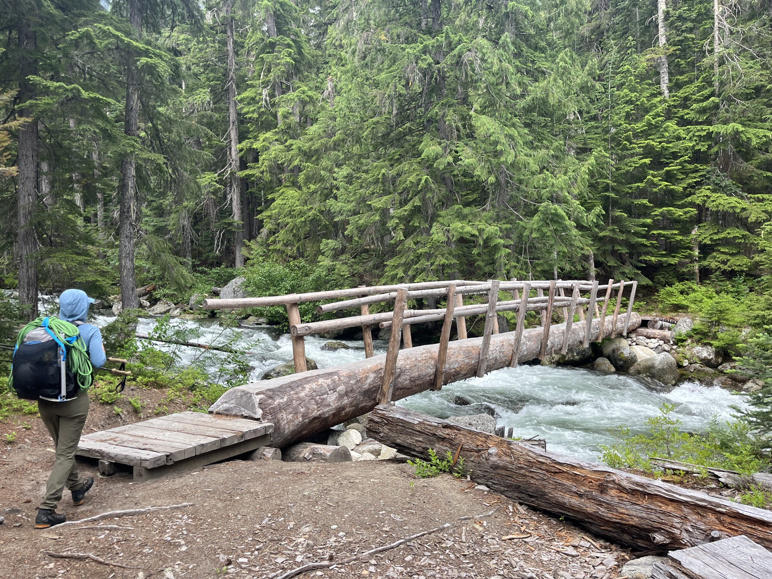 Carolyn hiking across a footbridge in the Glacier Peak Wilderness of the Cascades in Washington State