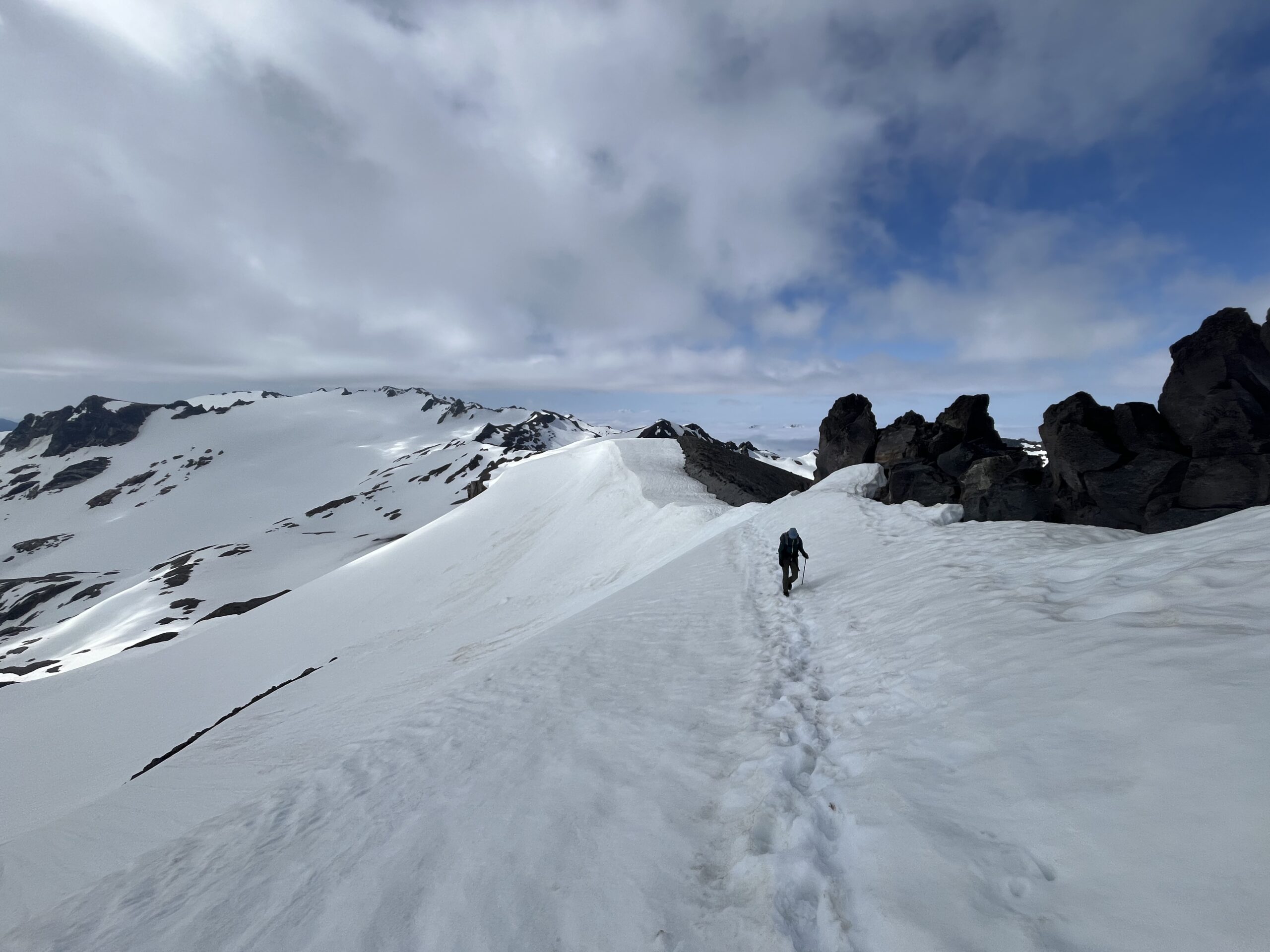 Carolyn hiking on the snow covered Disappointment Peak ridge line in the Glacier Peak Wilderness