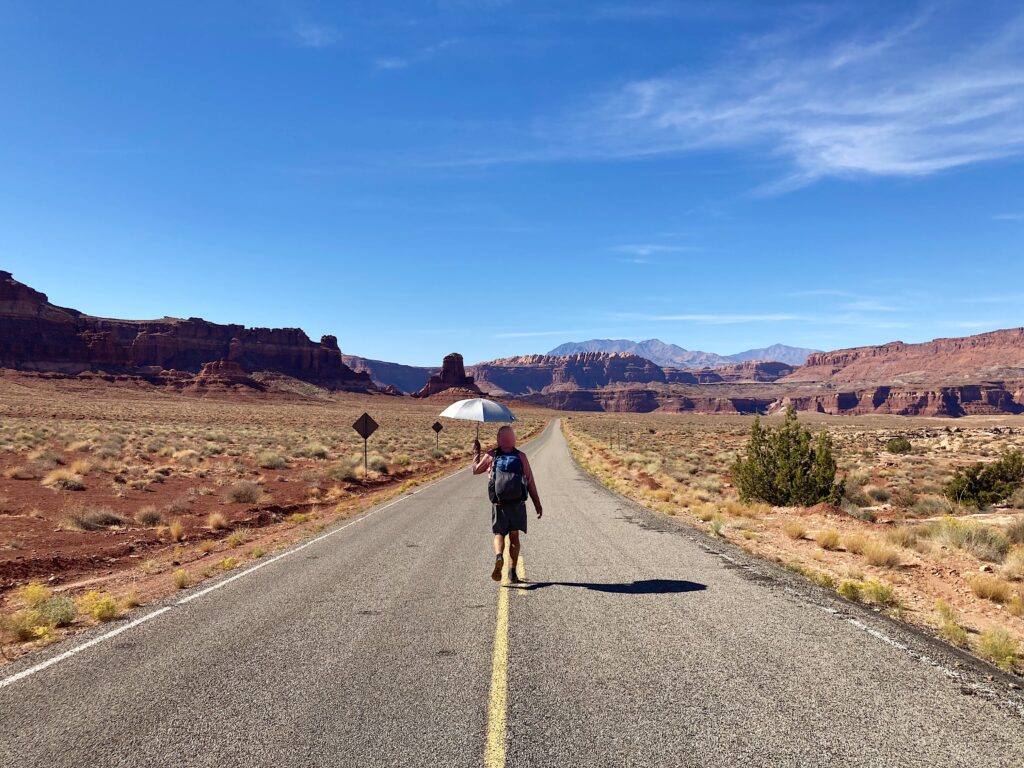 Jeff walking on the raod towards Hite Marina on the Hayduke Trail