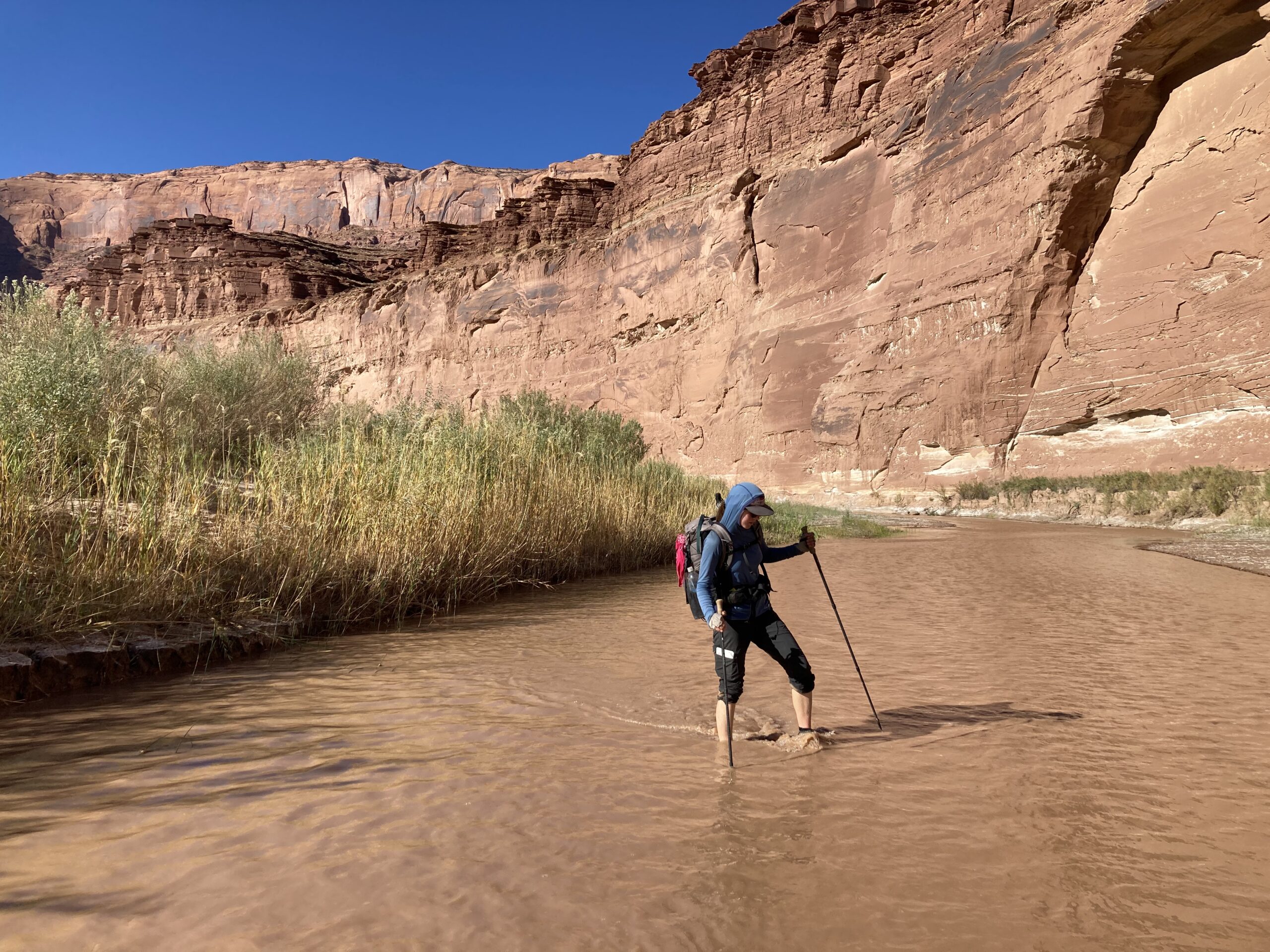 Carolyn walking through the Dirty Devil River on the Hayduke Trail