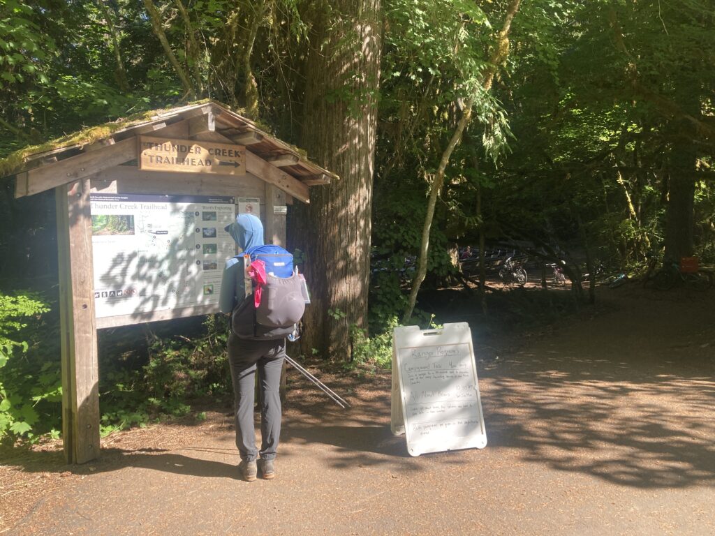 Carolyn standing next to the Thunder Creek trailhead sign in North Cascades National Park