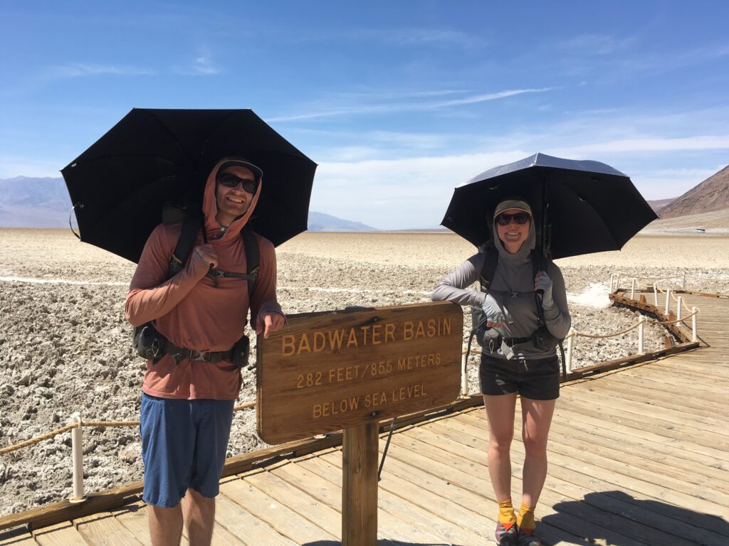 jeff and Carolyn standing beside the Badwater Basin sign at the start of the Lowest to Highest Route
