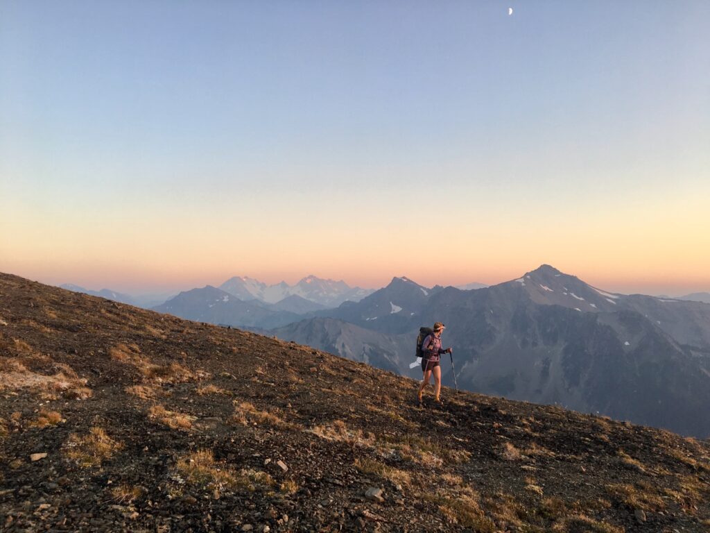 Carolyn hiking at sunset in Olympic National Park with mountain and alpine scenery.