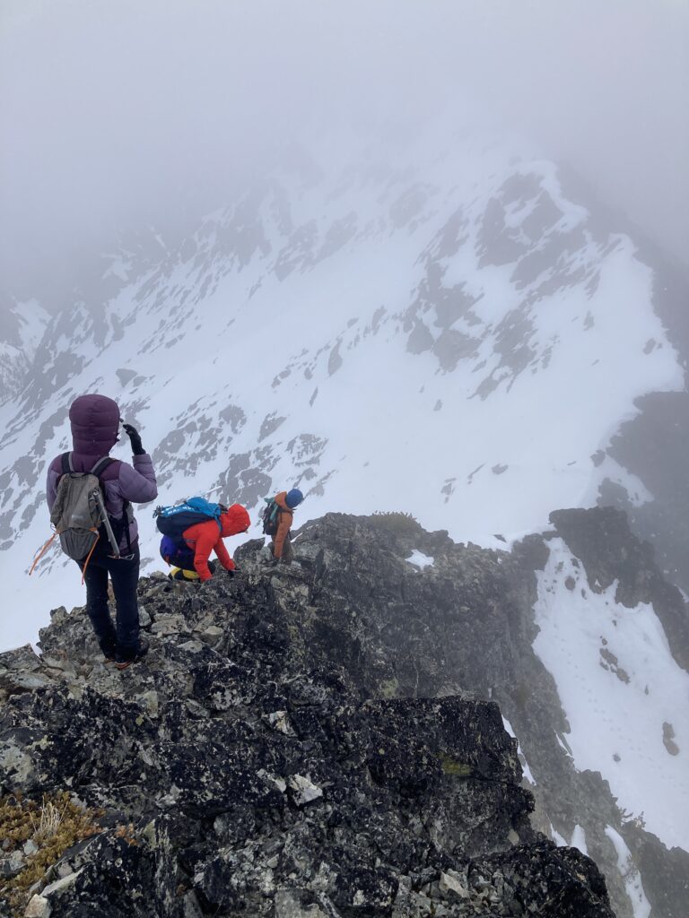 Climbers scrambling down 3rd class ridge on Robinson Mountain