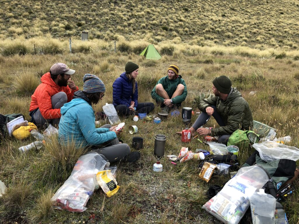 Hikers eating dinner at a campsite along the Te Araroa trail