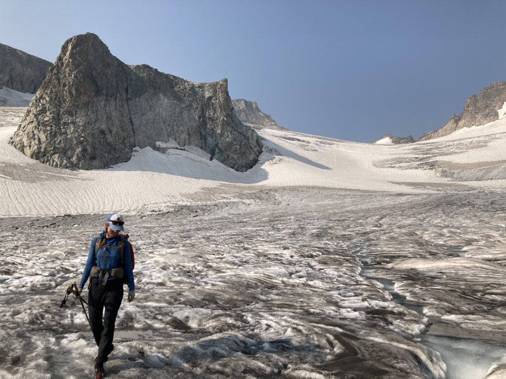 Glacier walking with alpine peaks behind Carolyn