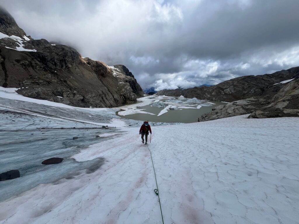 Hiker walking up the Colonial Glacier along the Isolation Traverse