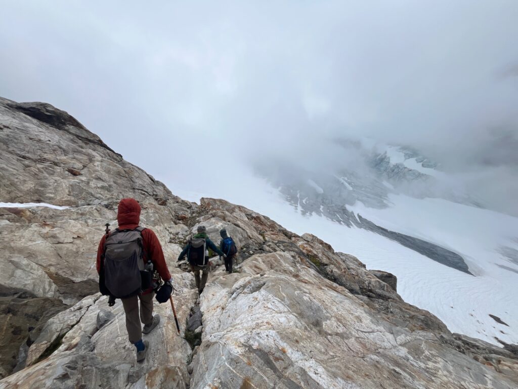 Hiker on a granite ramp on the Isolation Traverse in the North Cascades