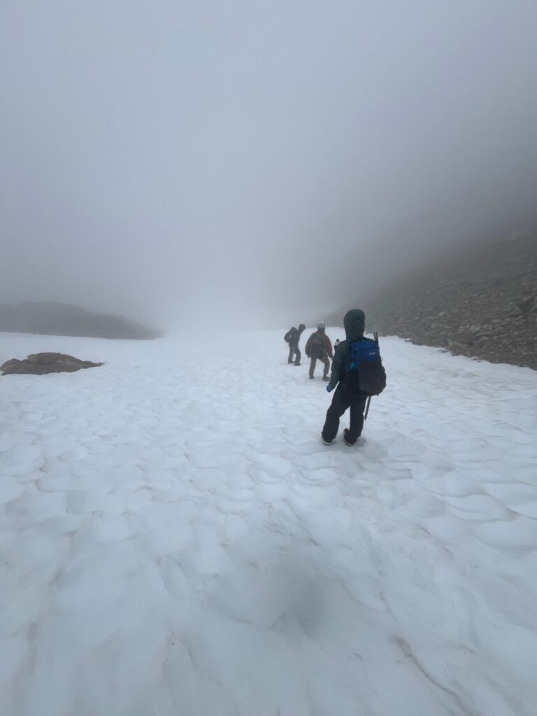 Climber descending from the ridge line of Snowfield Peak along the Isolation Traverse