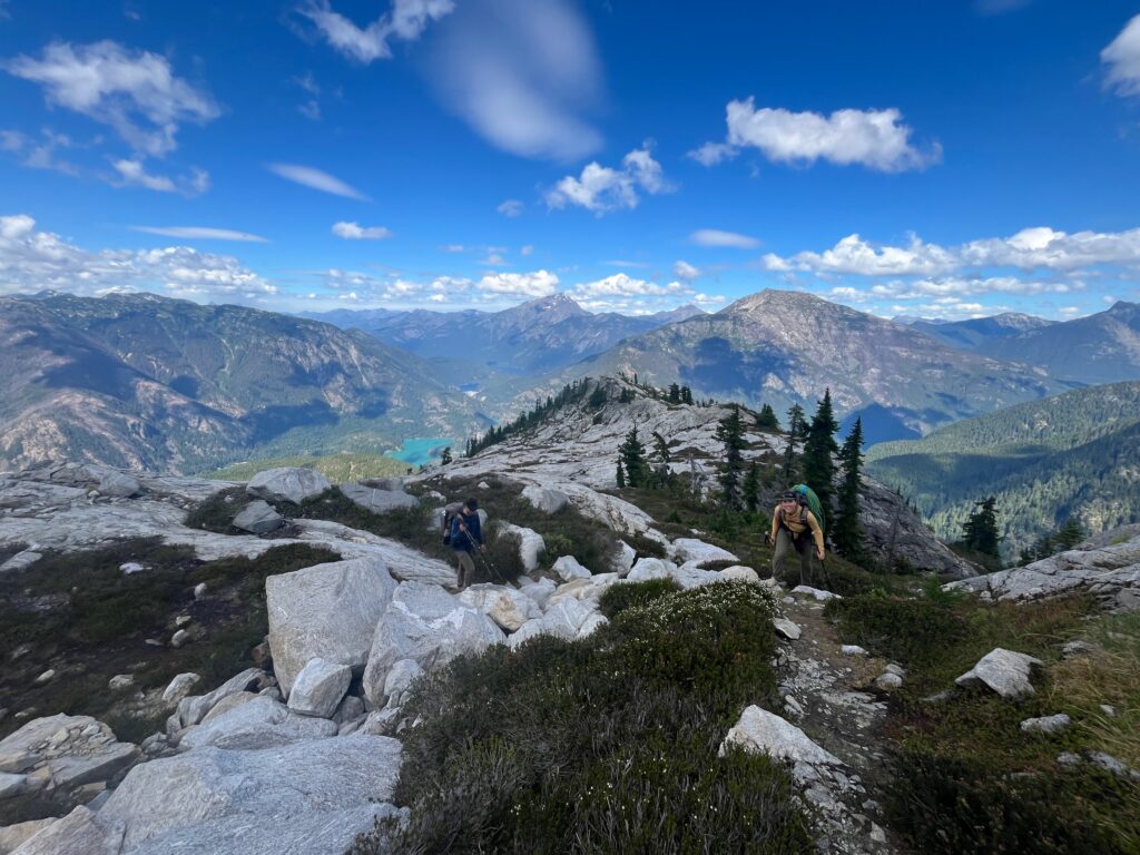 Hikers walking on the northeast shoulder of Pyramid Peak on the Isolation Traverse in the North Cascades
