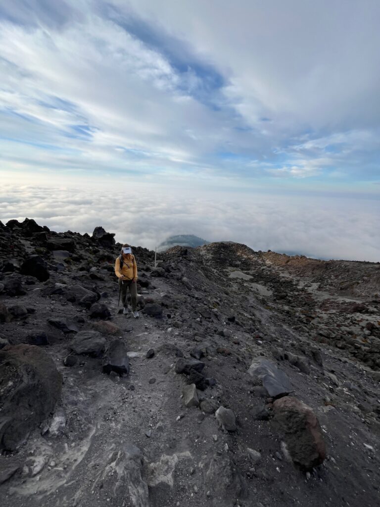 Carolyn walking up the ridgeline getting above the clouds